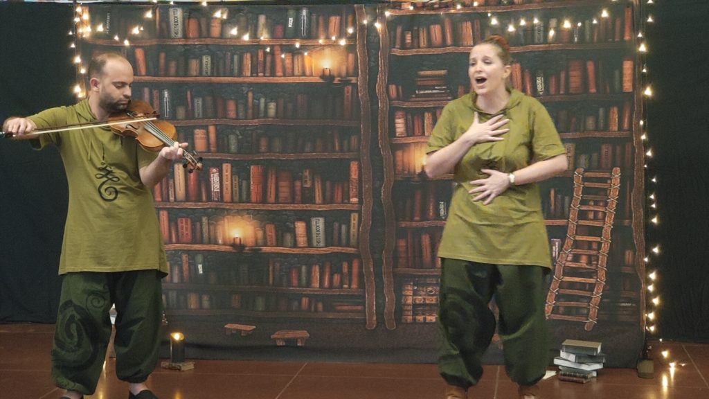 photo spectacle de contes, comédiens dans une bibliothèque qui jouent et chantent